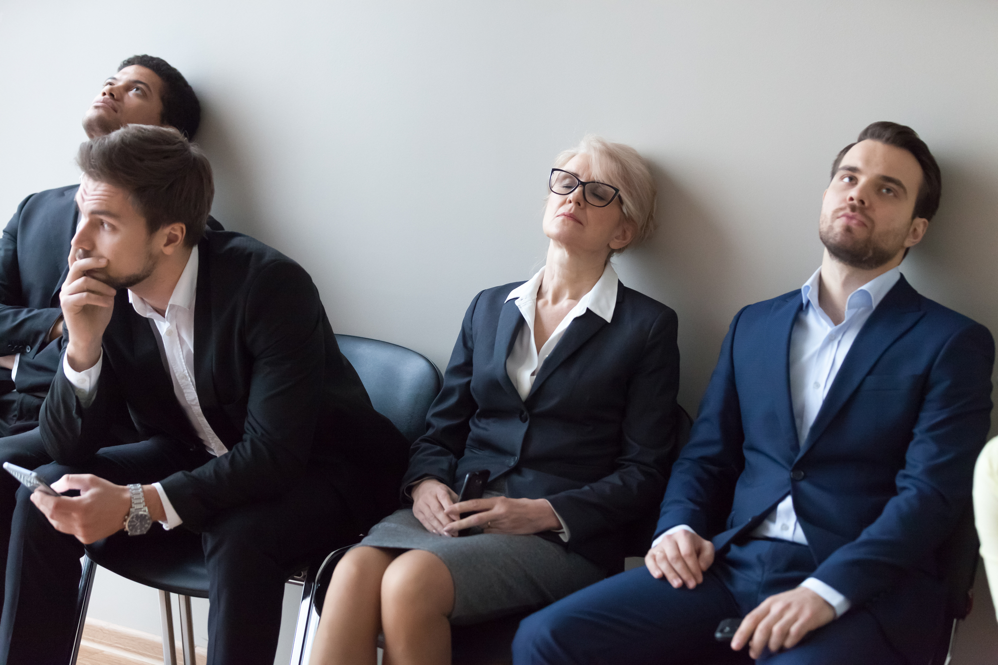 Diverse applicants getting bored in queue waiting for job interview