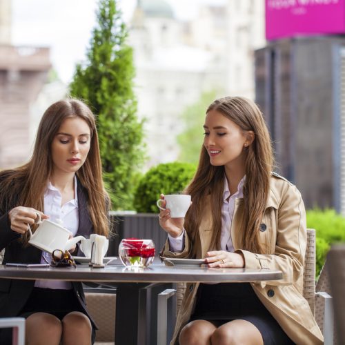 Two young business women having lunch break together